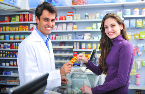 a male pharmacist and a lady customer smiling