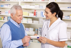 pharmacist showing the senior a box of medicine tablets